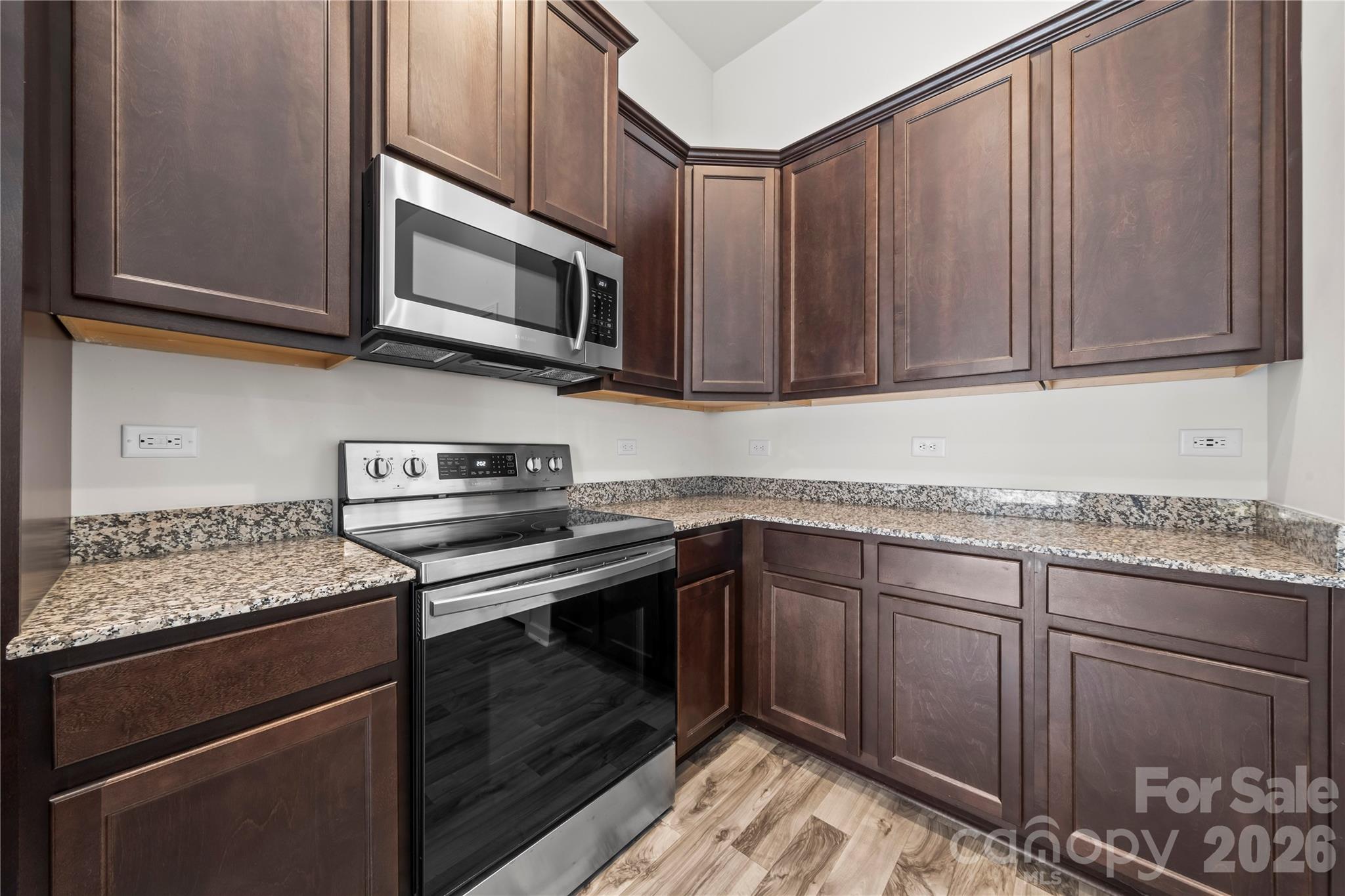7380 Latham Way Denver, NC 28037 - Photo 5 of 39 a kitchen with stainless steel appliances granite countertop a stove microwave and cabinets