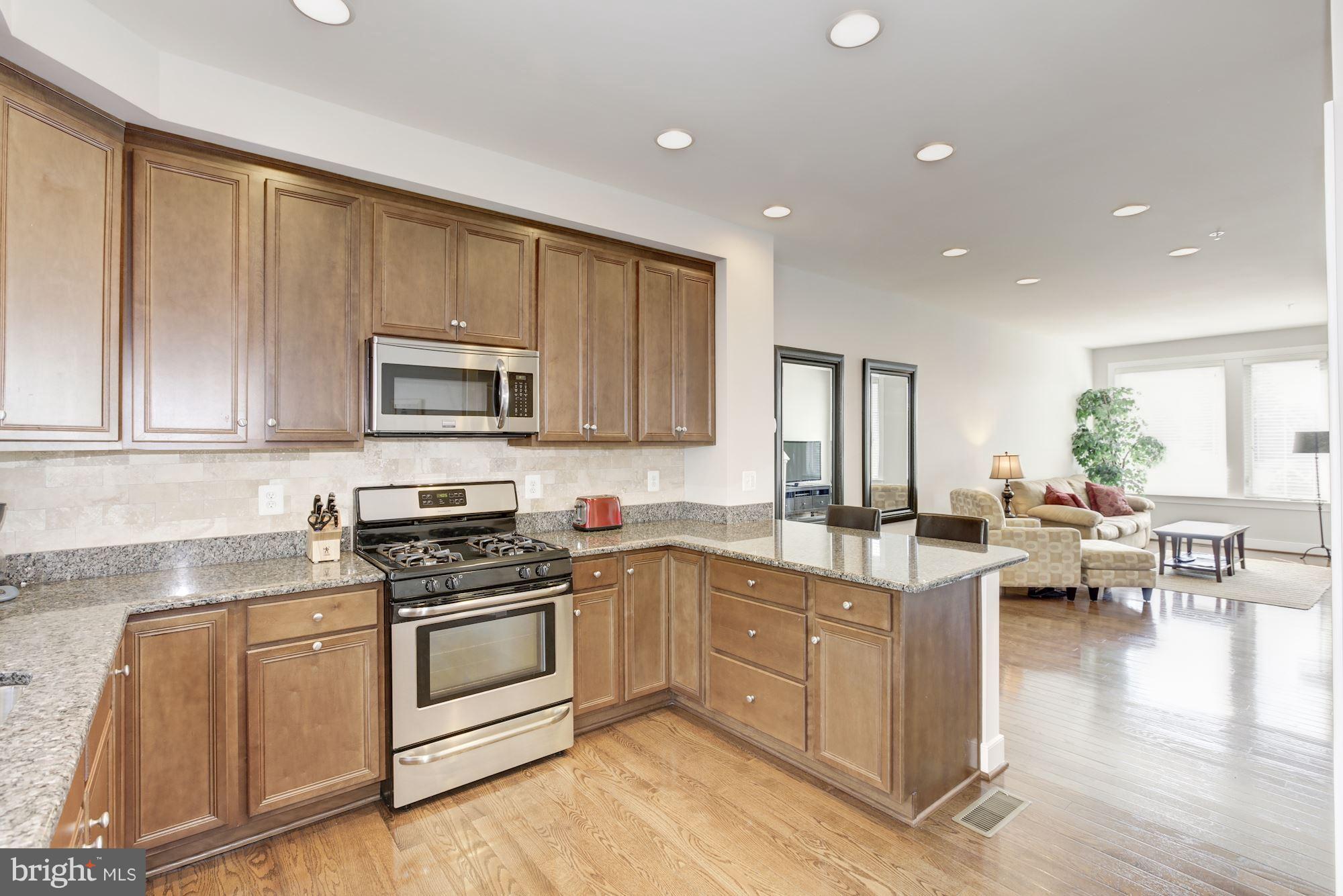 2957 Eskridge Road Fairfax, VA 22031 - Photo 5 of 30 a kitchen with white cabinets stainless steel appliances and wooden floor