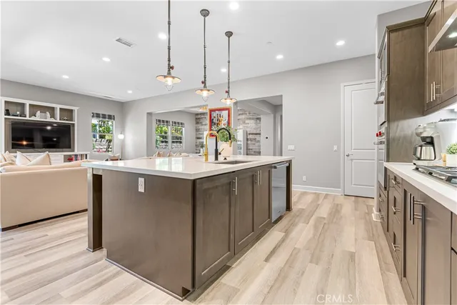 a kitchen with kitchen island granite countertop a sink a counter top space stainless steel appliances and cabinets