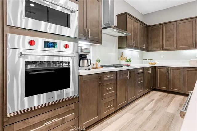 a kitchen with stainless steel appliances granite countertop a stove a sink a oven a dining table and chairs