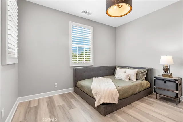 a swimming pool with lawn chairs under an umbrella and palm trees