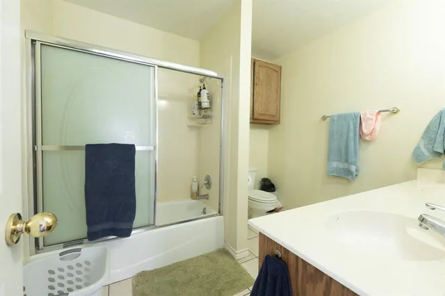 a spacious bedroom with a bed and a chandelier