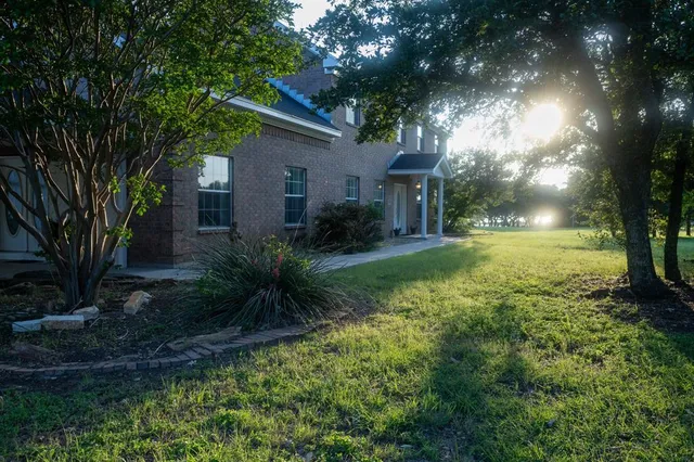 a view of a house with garden and trees