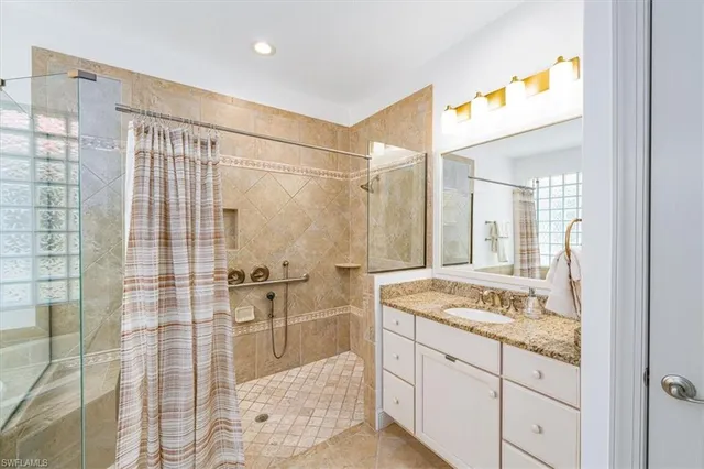a spacious bathroom with a granite countertop sink mirror and shower