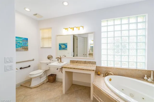 a bathroom with a bathtub sink mirror vanity and toilet