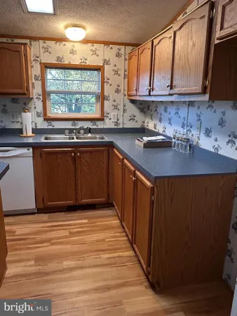 a kitchen with stainless steel appliances granite countertop a sink window and cabinets