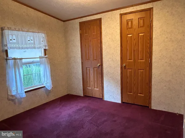an empty room with windows and closet