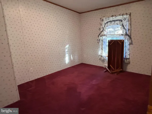 an empty room with a fireplace and mirror
