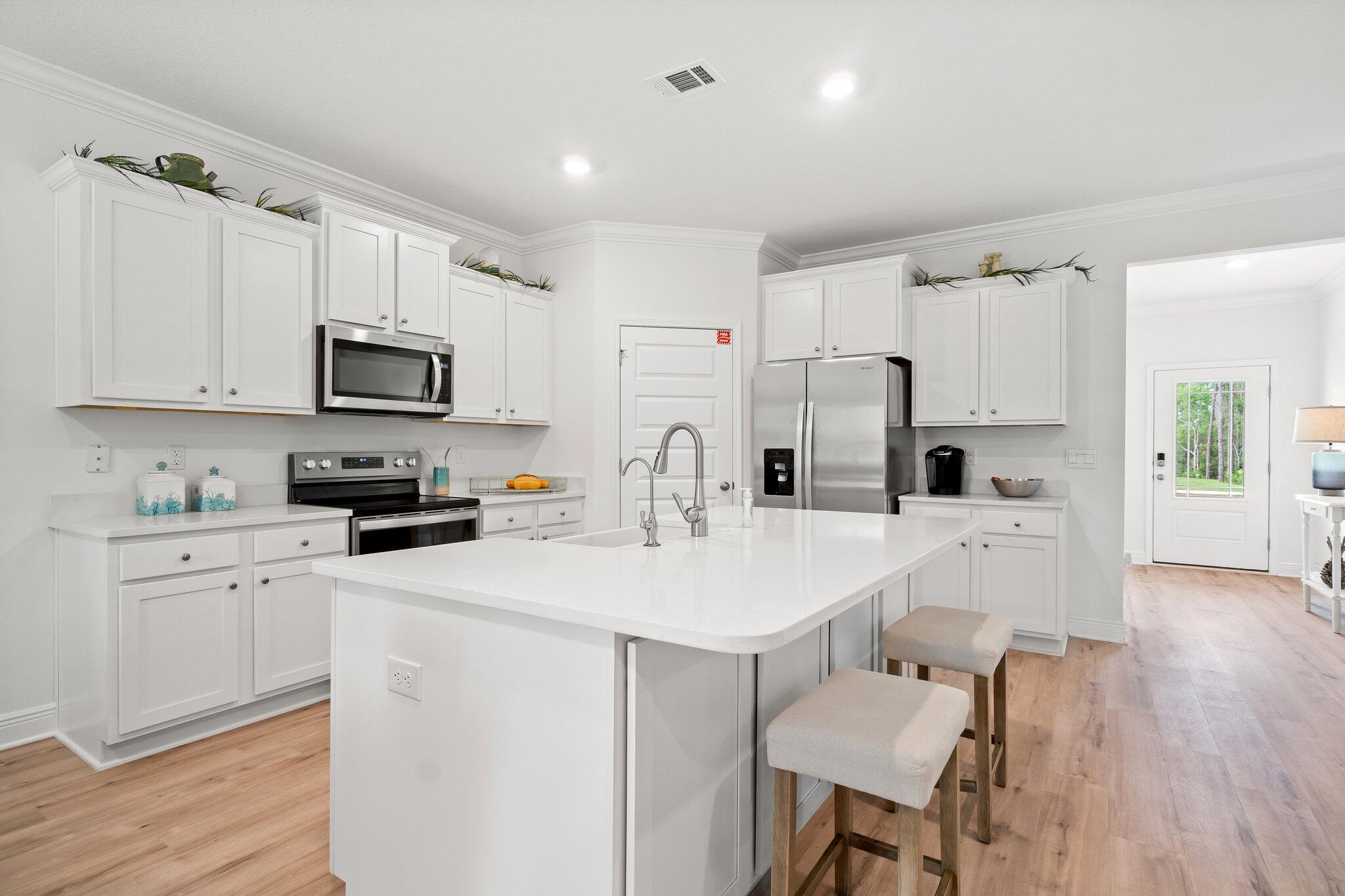 12096 East Harborview Road, Unit LOT 34 Santa Rosa Beach, FL 32459 - Photo 4 of 14 a kitchen with white cabinets and stainless steel appliances