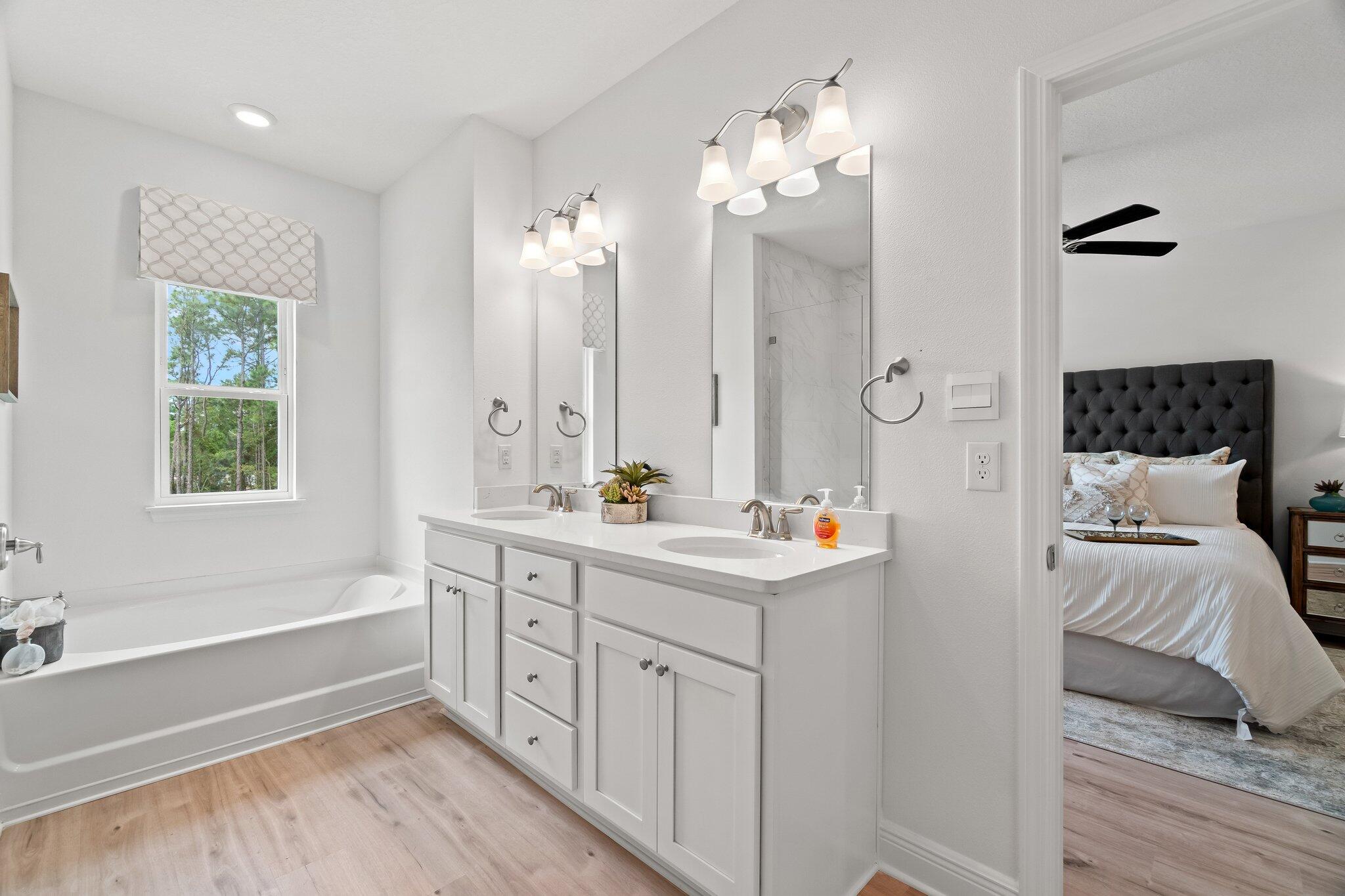 12096 East Harborview Road, Unit LOT 34 Santa Rosa Beach, FL 32459 - Photo 9 of 14 a spacious bathroom with a double vanity sink a large mirror and a bathtub