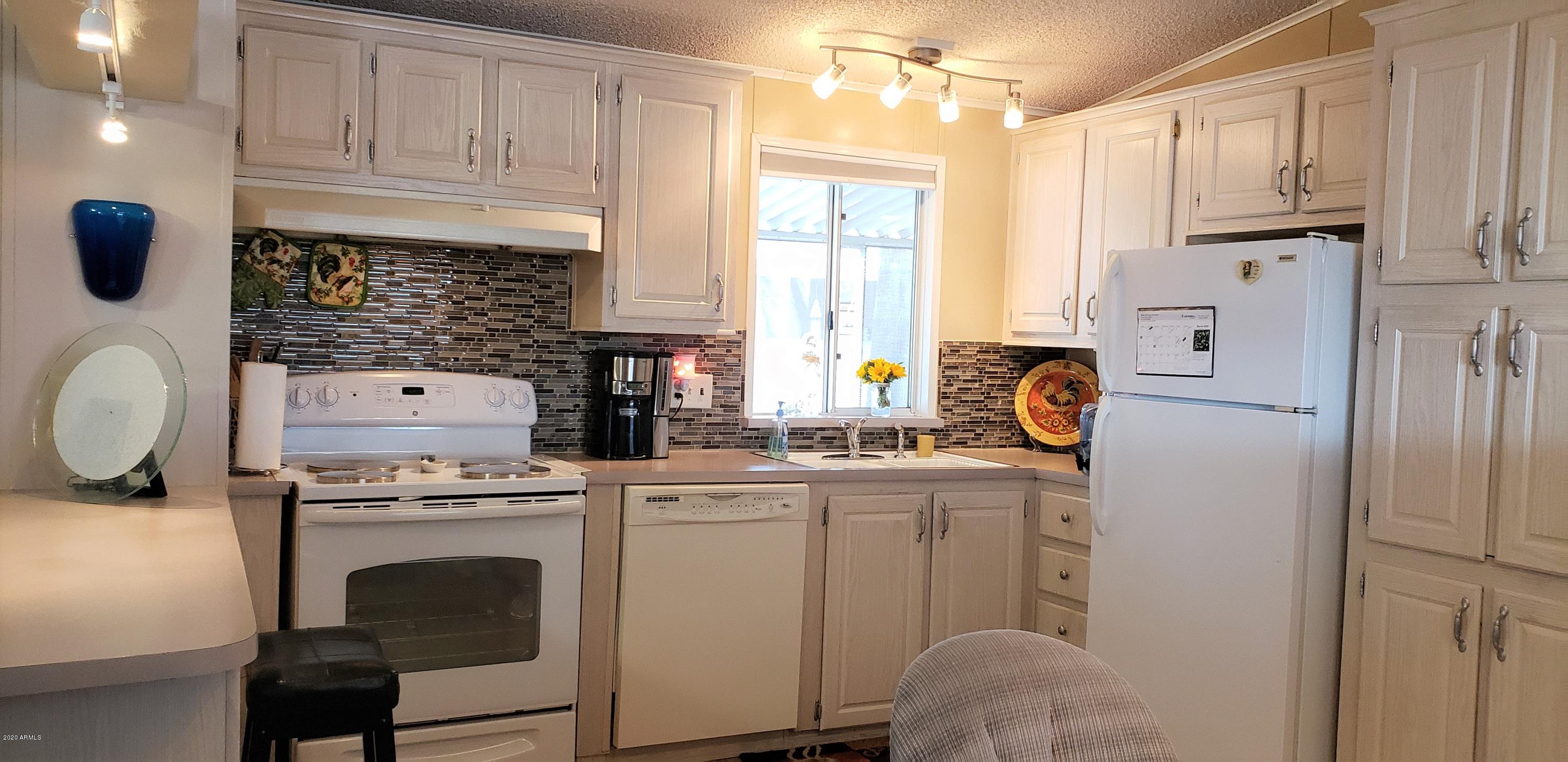 301 South Signal Butte Road, Unit 226 Apache Junction, AZ 85120 - Photo 11 of 42 a kitchen with appliances cabinets and a sink