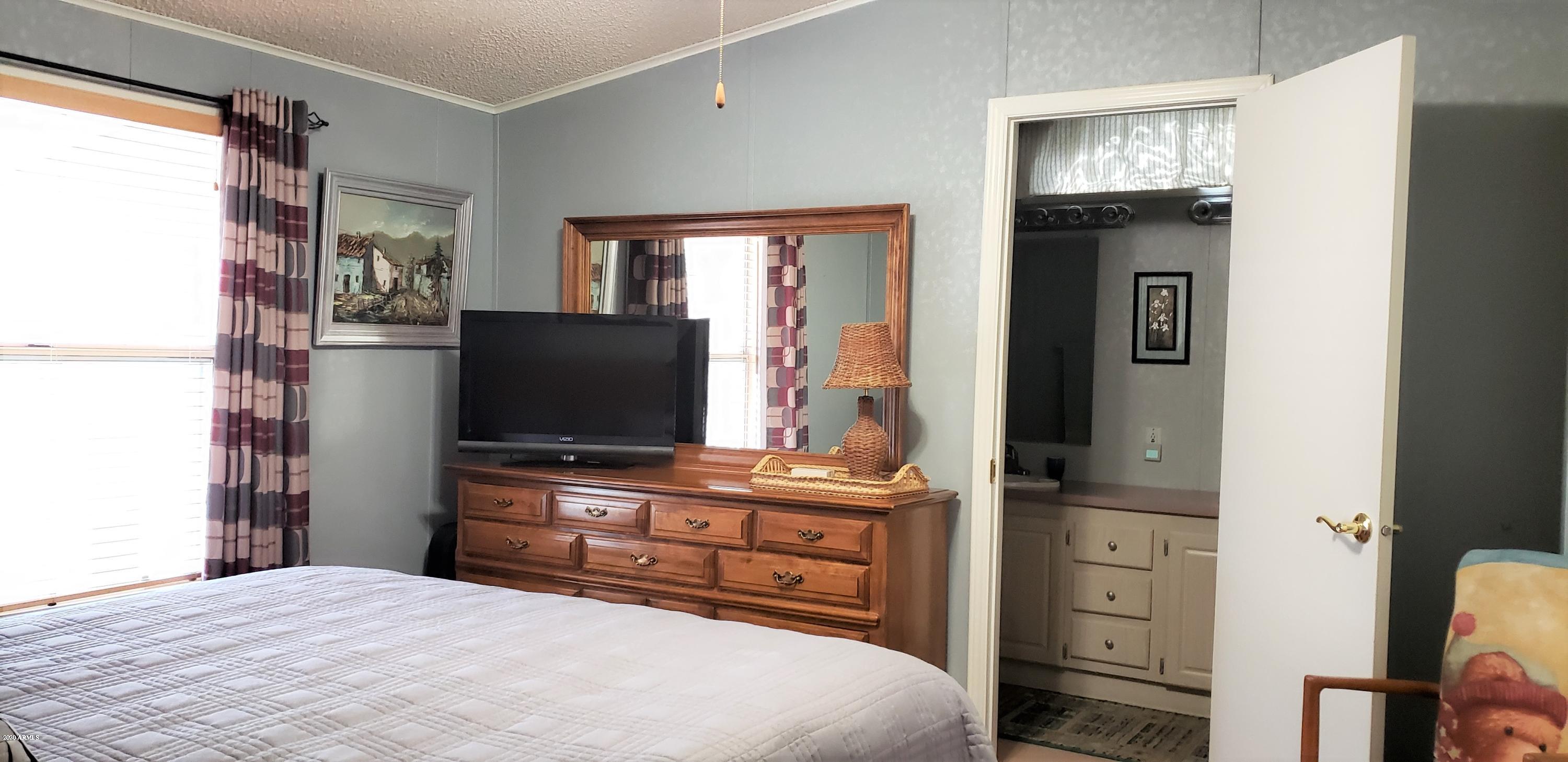301 South Signal Butte Road, Unit 226 Apache Junction, AZ 85120 - Photo 17 of 42 a bedroom with a bed and a flat screen tv