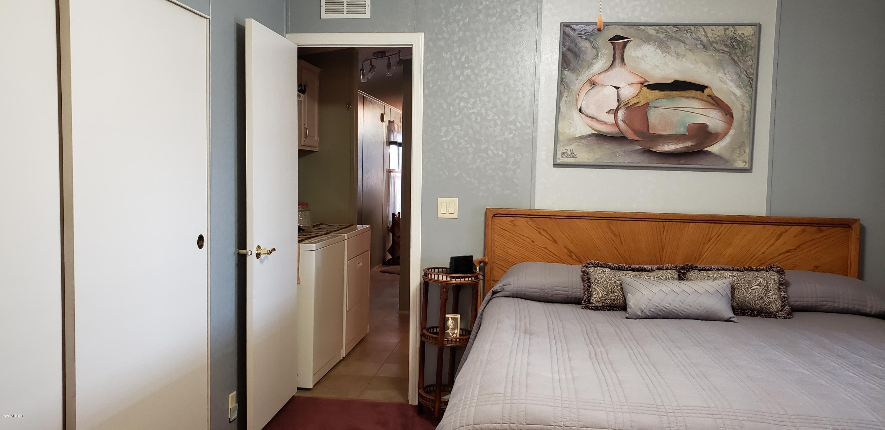 301 South Signal Butte Road, Unit 226 Apache Junction, AZ 85120 - Photo 21 of 42 a bedroom with a bed and wall painting