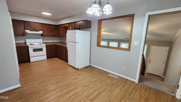 a kitchen with stainless steel appliances wooden floors and refrigerator