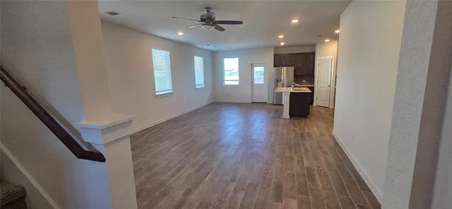 a view of kitchen with refrigerator stove and wooden floor