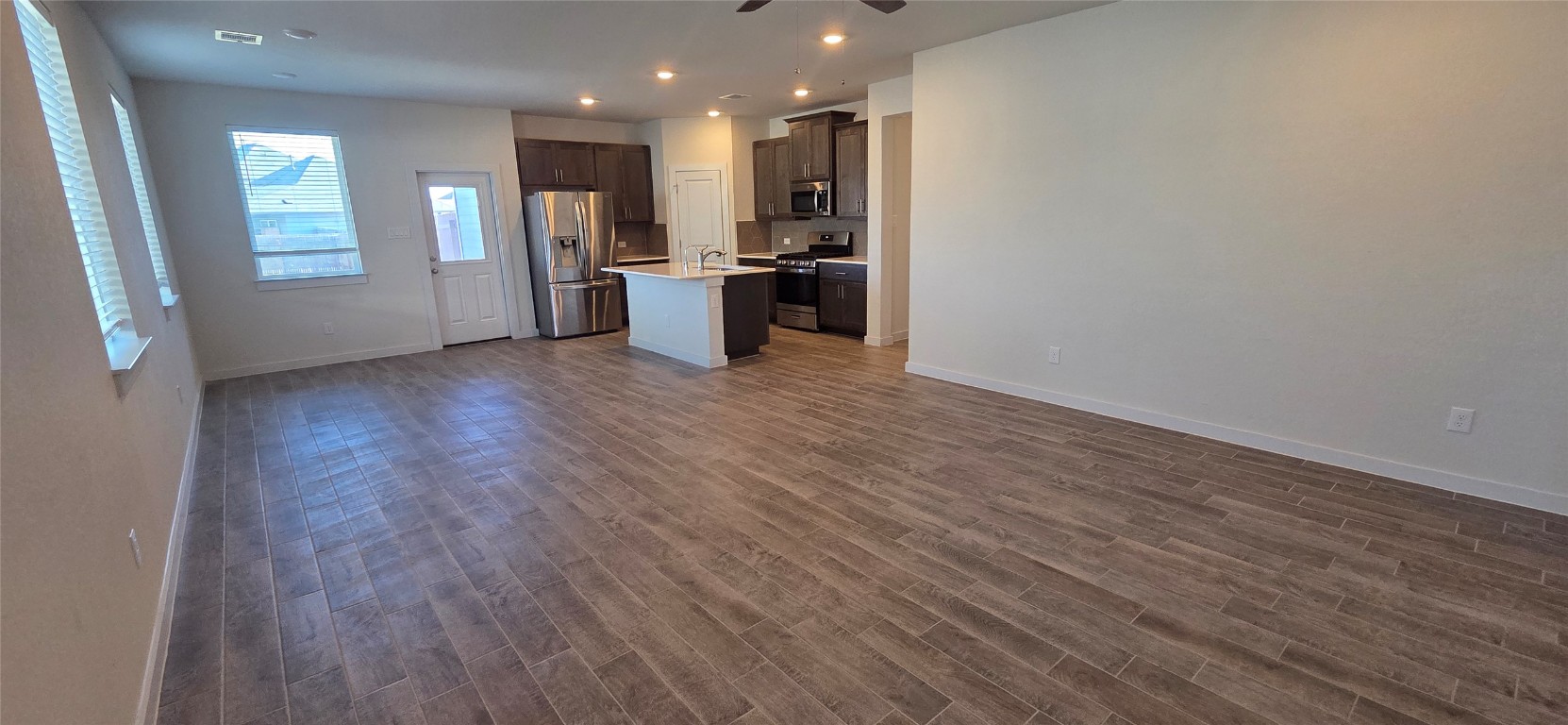 212 Whisper Rill Drive Hutto, TX 78634 - Photo 3 of 25 a view of kitchen with refrigerator stove and wooden floor