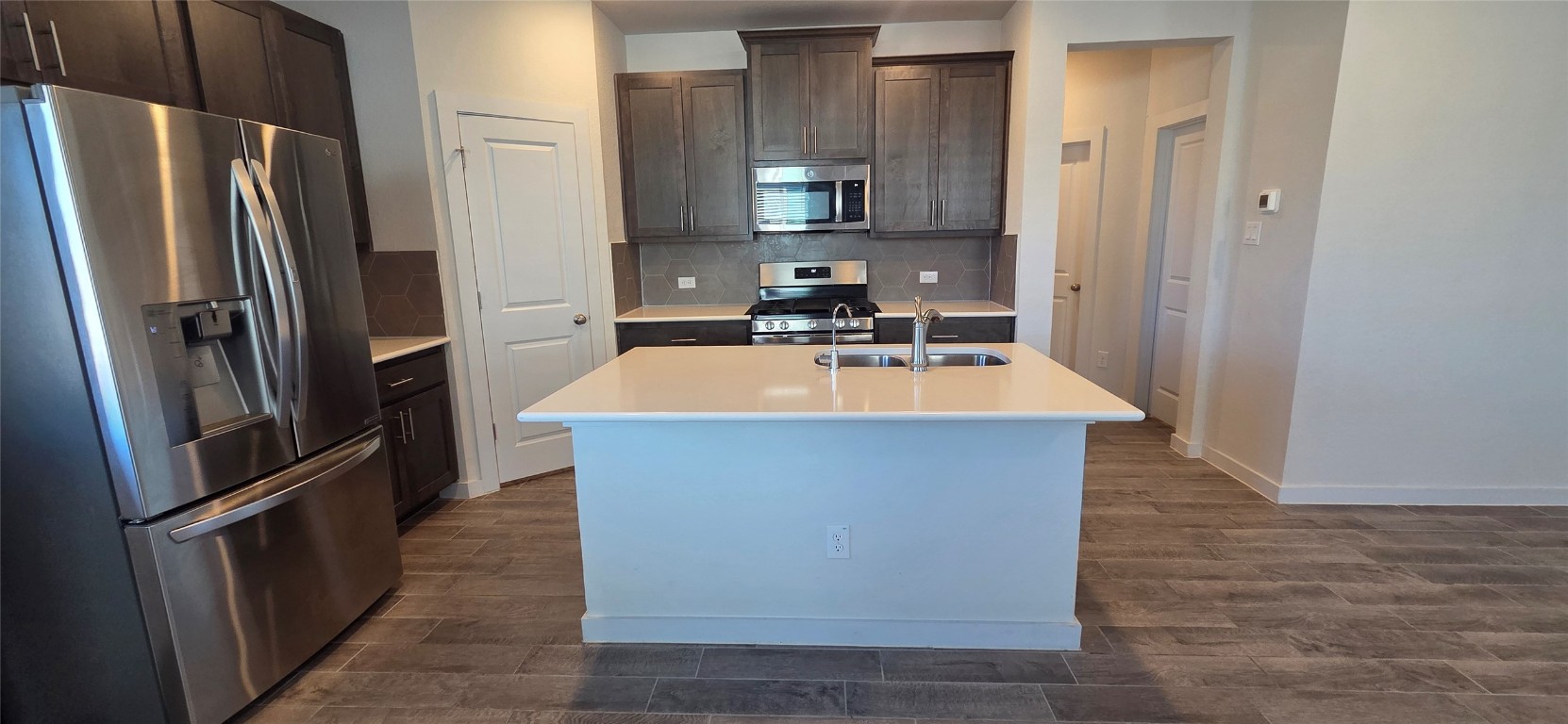 212 Whisper Rill Drive Hutto, TX 78634 - Photo 4 of 25 a kitchen with stainless steel appliances a refrigerator a sink a stove and cabinets