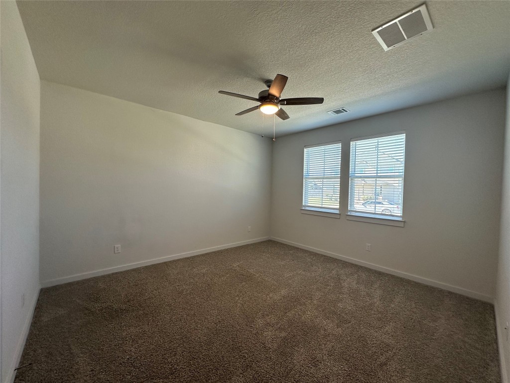 212 Whisper Rill Drive Hutto, TX 78634 - Photo 7 of 25 an empty room with a window and a ceiling fan