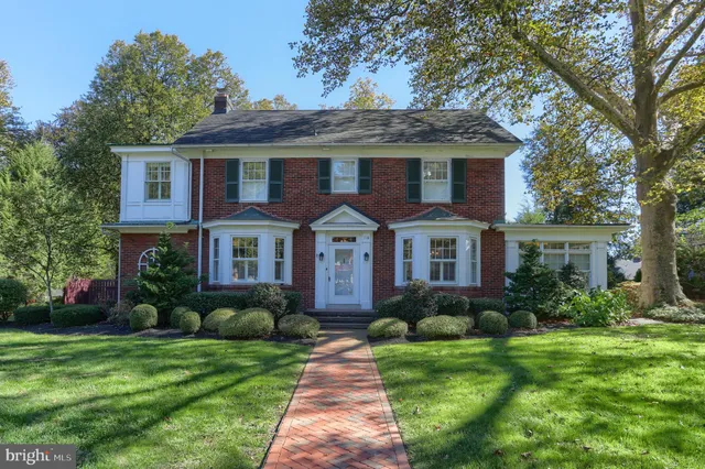 a front view of a house with a yard and potted plants