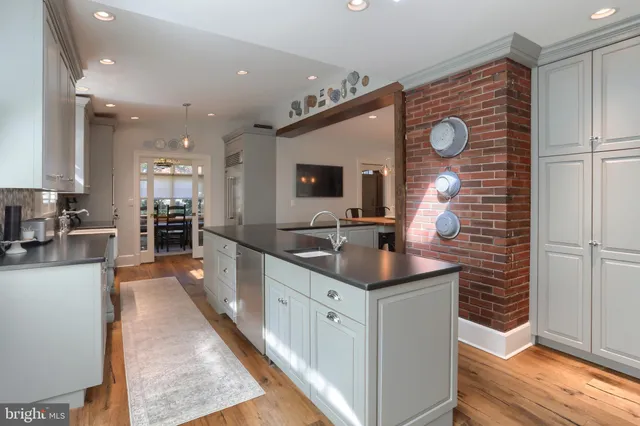 a kitchen with granite countertop a stove a sink a dining table and chairs