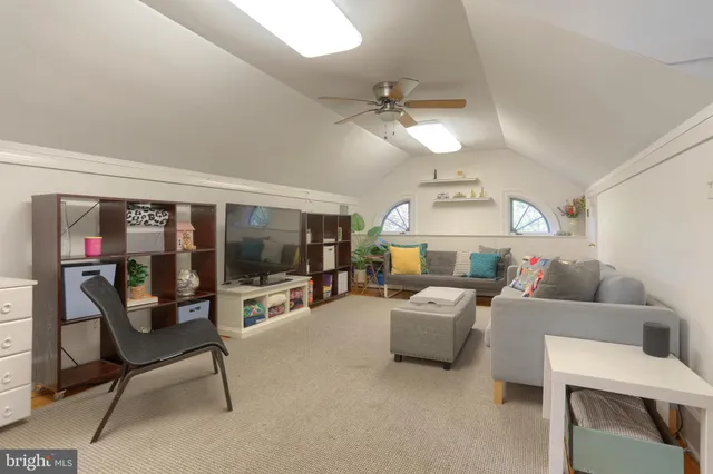 a living room with furniture and a ceiling fan