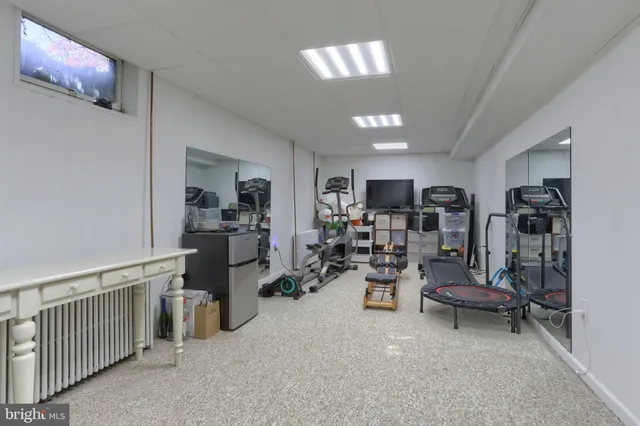 a view of a brick house with many windows plants and large trees
