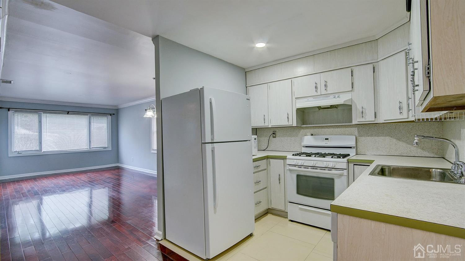 10 Melville Road Edison, NJ 08817 - Photo 10 of 32 a kitchen with stainless steel appliances a stove a sink a refrigerator white cabinets and wooden floor