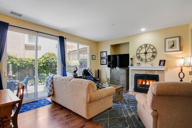 a living room with furniture a fireplace and a large window