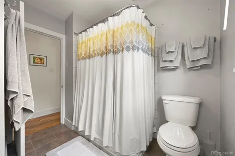 a white toilet sitting next to a bathroom sink and a shower