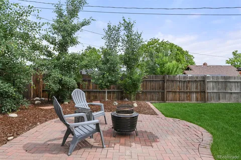 a view of a patio with table and chairs potted plants and wooden fence