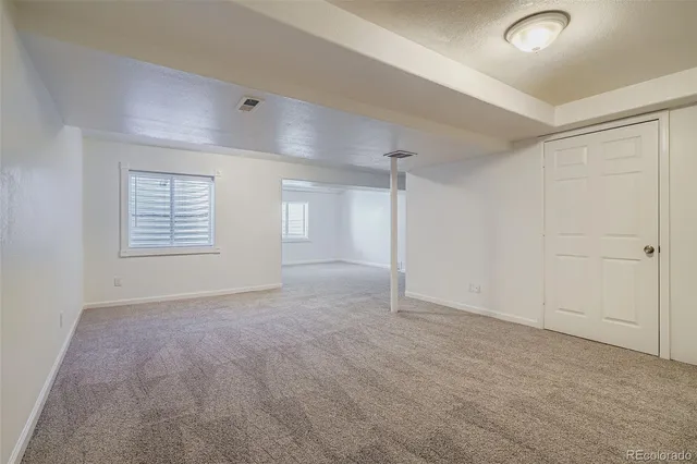 an empty room with closet and windows