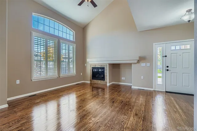 a view of an empty room with wooden floor and staircase