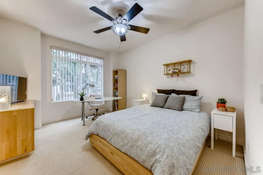 9263 Regents Road, Unit B203 La Jolla, CA 92037 - Photo 19 of 25 a bedroom with a bed and a chandelier