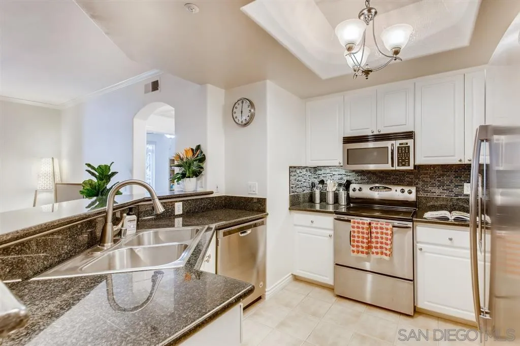 9263 Regents Road, Unit B203 La Jolla, CA 92037 - Photo 5 of 25 a kitchen with stainless steel appliances granite countertop a sink and stove