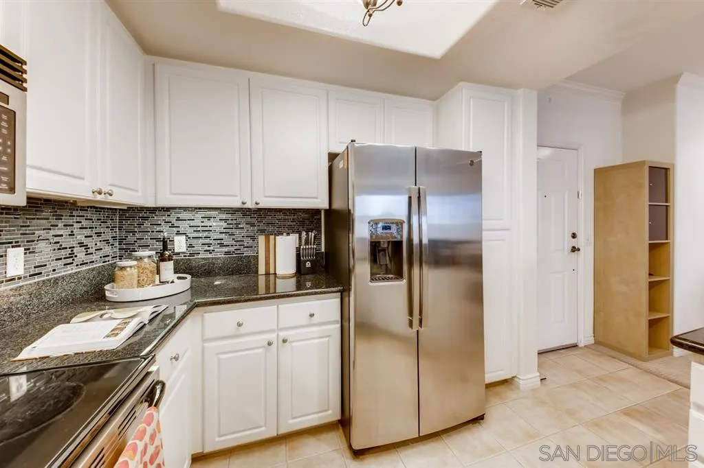 9263 Regents Road, Unit B203 La Jolla, CA 92037 - Photo 9 of 25 a kitchen with stainless steel appliances a refrigerator sink and cabinets