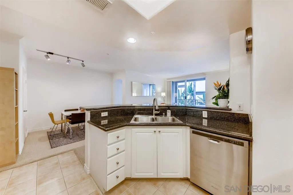 9263 Regents Road, Unit B203 La Jolla, CA 92037 - Photo 10 of 25 a kitchen with granite countertop a sink and cabinets
