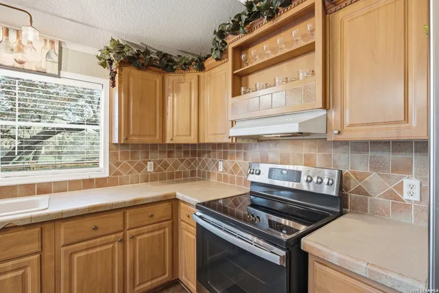 a kitchen with stainless steel appliances a stove and a window