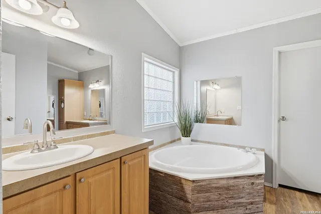 a bathroom with a granite countertop sink and a bathtub