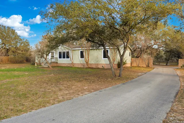 a front view of a house with a yard and trees