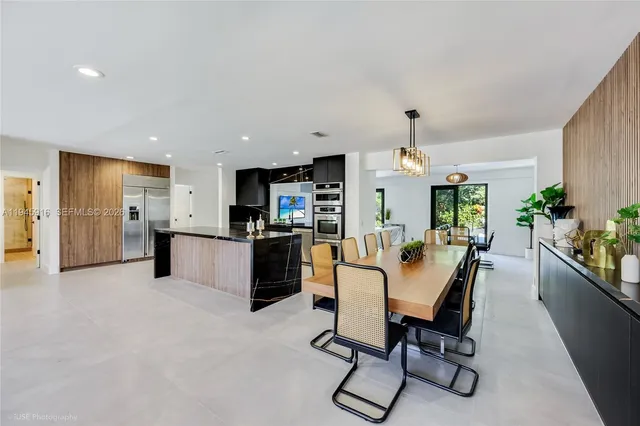 a dining room with furniture and kitchen view
