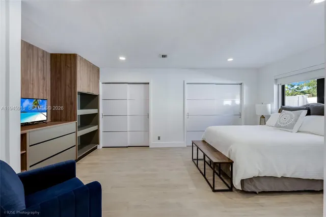 a spacious bedroom with a bed and a dresser