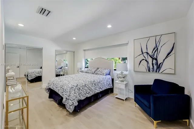 a spacious bedroom with a bed and dresser