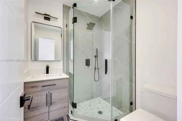 a bathroom with a sink a toilet and shower