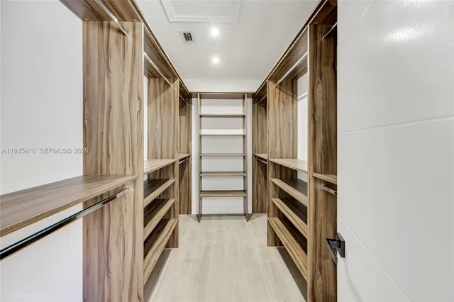 a view of walk in closet with empty racks