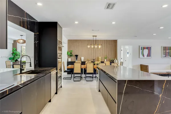 a large kitchen with lots of counter space a sink and chairs