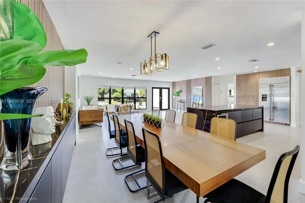 a living room with furniture a chandelier and a floor to ceiling window