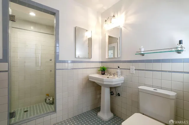 a bathroom with a sink a toilet and shower