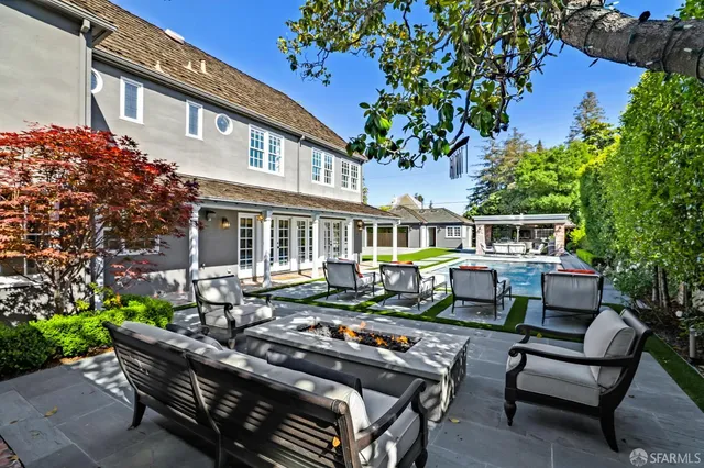 a view of a house with a chairs and table in a patio