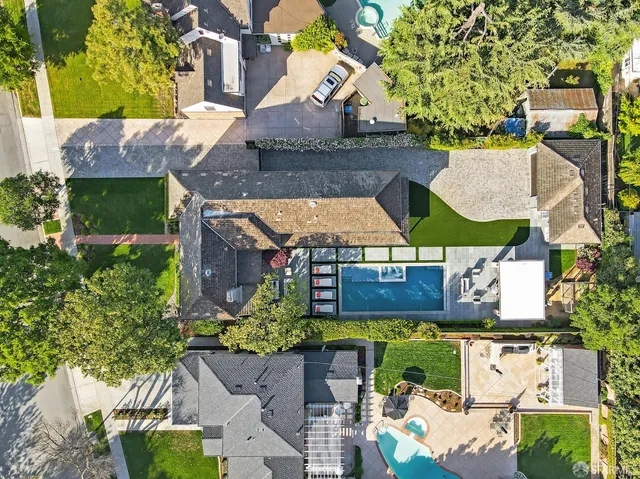 an aerial view of residential houses with outdoor space and swimming pool