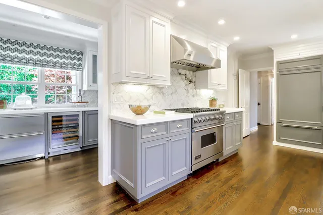 a kitchen with stainless steel appliances a stove a sink and a refrigerator